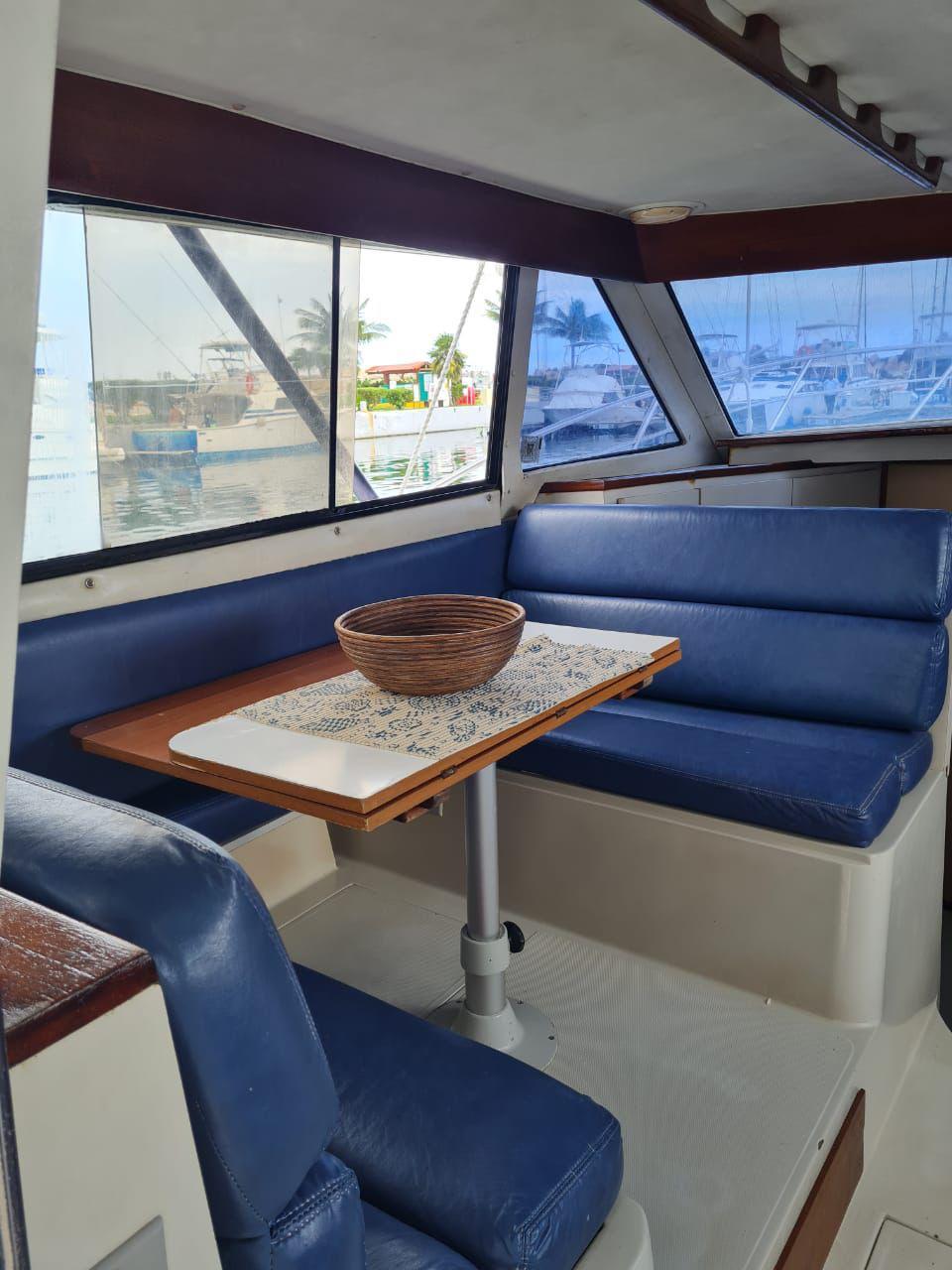 Inside the fishing charter in Puerto Morelos — dinette table and blue seating in the salon