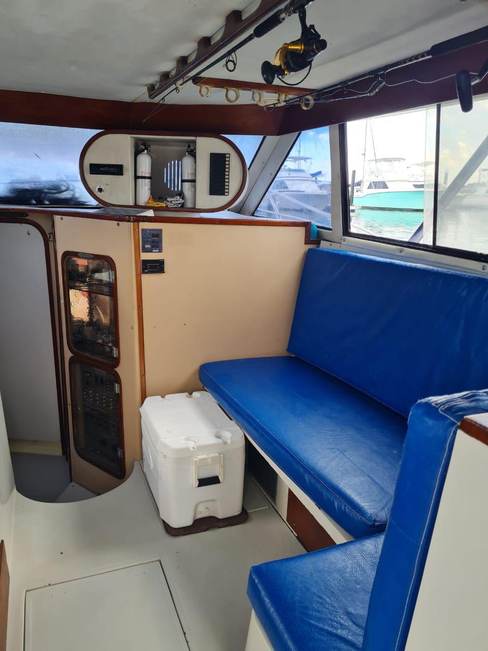 Salon of the fishing boat in Puerto Morelos with blue bench seating and a cooler